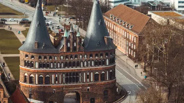 Historisches Tor in städtischer Straßenumgebung.