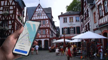 Hand holding smartphone with map in German village.