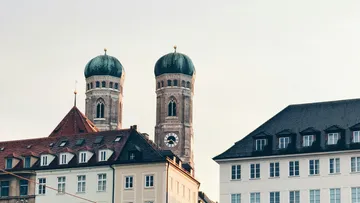 Two church towers behind urban buildings.