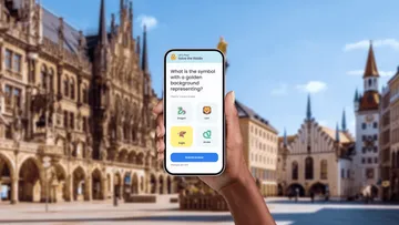Hand holds phone with quiz app open.