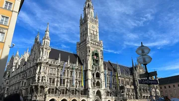 Gothic building with clock tower under blue sky.