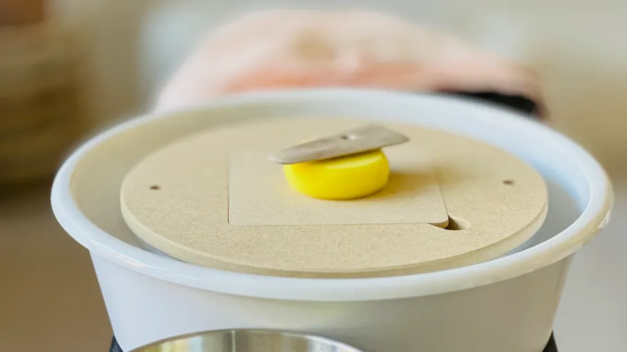 Ice cream machine with yellow lid inside.