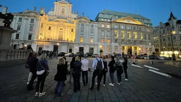 Menschen stehen, betrachten beleuchtete historische Gebäude.