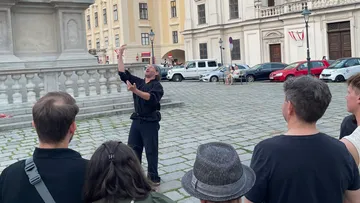 Straßenkünstler unterhält Publikum auf historischem Platz.