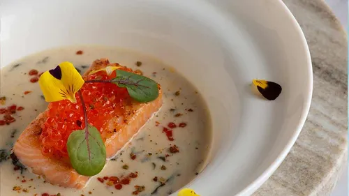 Gourmet salmon dish in a white bowl.