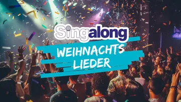 Crowd singing in concert, colorful lights.