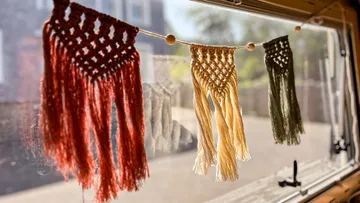 Bunte Makramee-Hänger an einem Fenster.