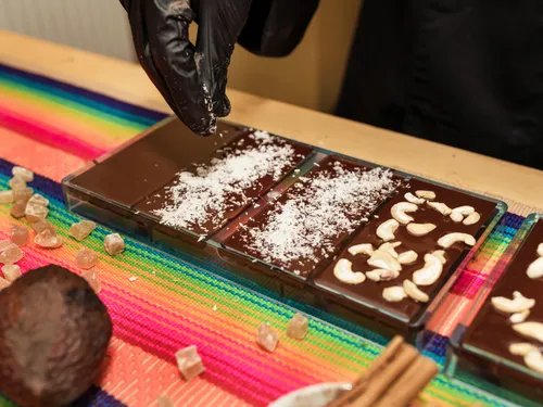 Chocolate is decorated with coconut and cashew nuts.