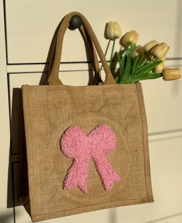 Braune Tasche mit rosa Schleife, Tulpen darin.