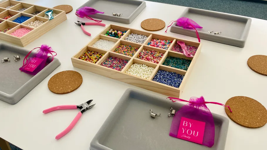 Beading workshop setup with tools and beads.