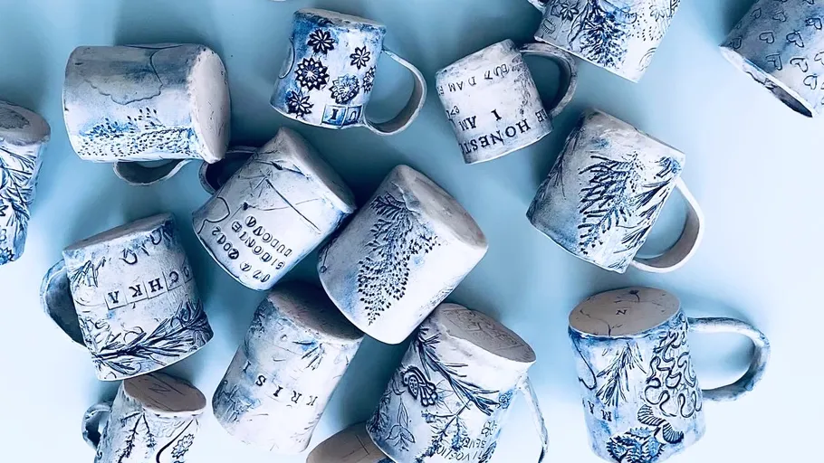 Decorative mugs with floral patterns on light background.