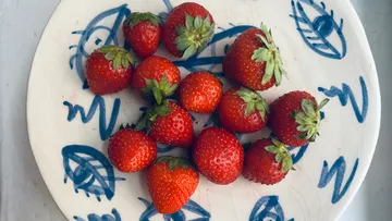 Erdbeeren auf einem dekorativen Teller angeordnet.