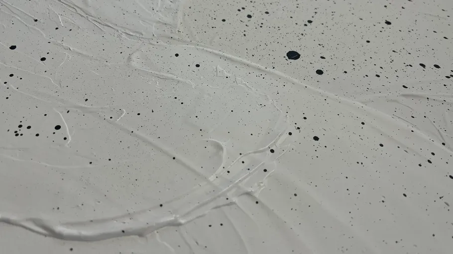 White surface with black paint splatters.
