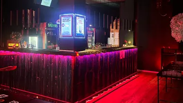 Bar mit Neonlichtern, Getränke auf Tresen.