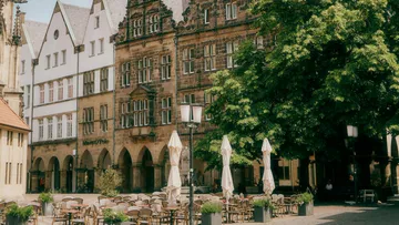 Empty outdoor cafe seating with historic buildings.