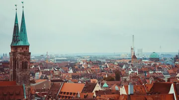 Stadtbild mit Kirchtürmen und Gebäuden.