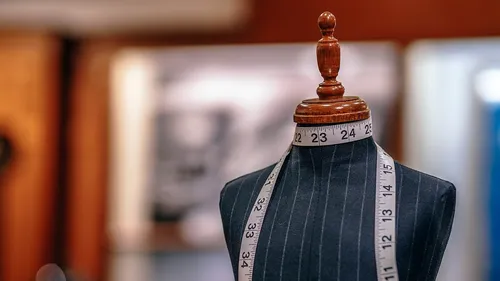 Tailor's mannequin with measuring tape in studio.