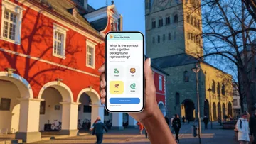 Person hält Smartphone mit Rätselspiel.