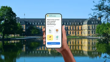 Hand hält Smartphone mit Quiz-App, Gebäude reflektiert.