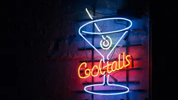 Neon-Cocktailglas-Schild an Wand.