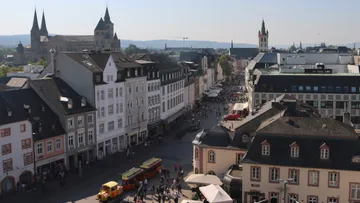 Stadtplatz mit historischen Gebäuden und Menschen.