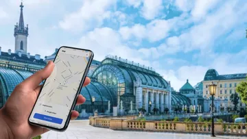 Hand holding phone with map app open.