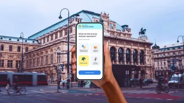 Hand hält Handy mit Quiz in Stadtstraße.