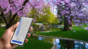Hand hält Telefon mit Karten-App geöffnet.