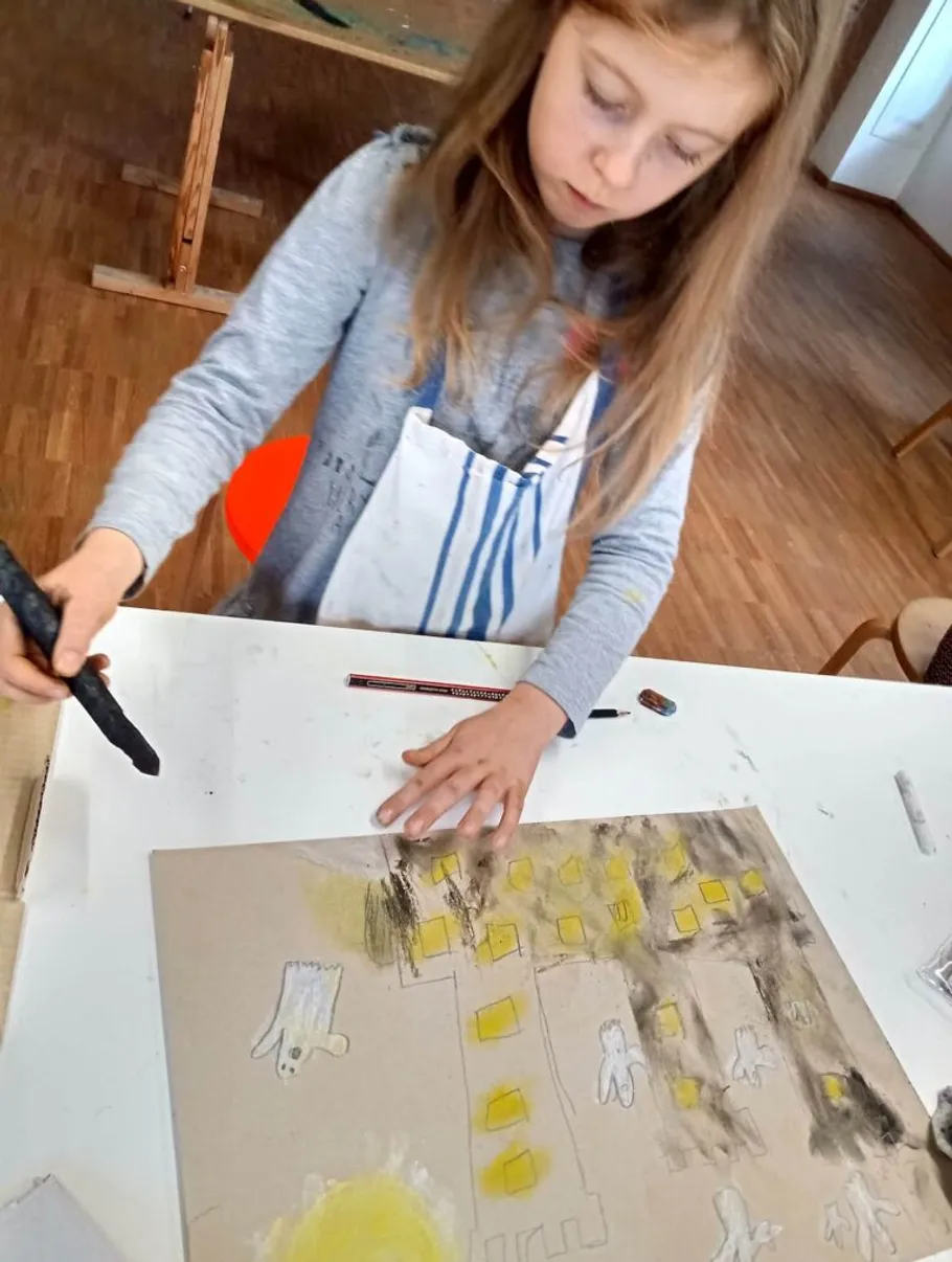 Kind malt Kunstwerk am Klassentisch.