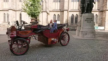 Oldtimer parkt nahe Johann-Sebastian-Bach-Statue.