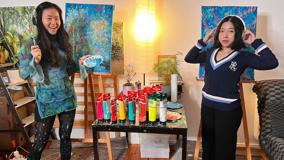 Zwei Frauen mit Kopfhörern im Kunststudio.
