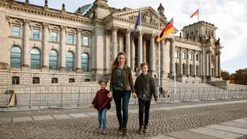 Familie läuft vor dem Reichstagsgebäude.