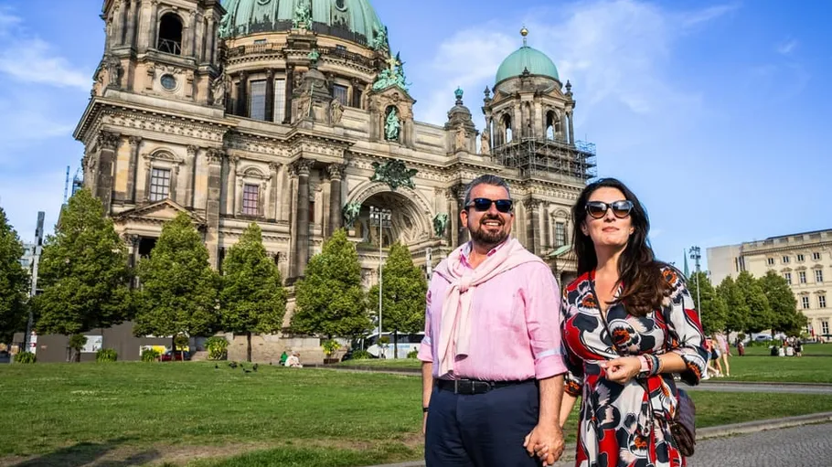 Couple walks in front of historic cathedral.