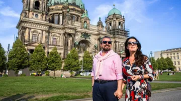 Paar steht vor historischem Gebäude.