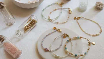 Bunte Perlenarmbänder mit Flaschen auf einem Tisch.