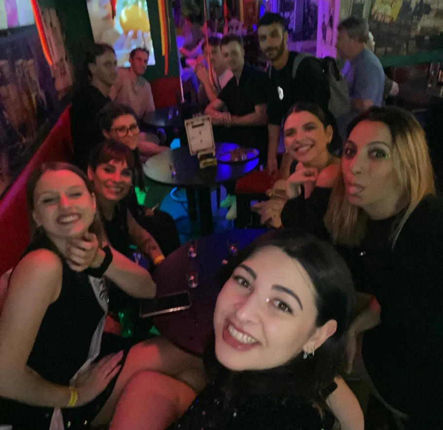 Group of people smiling in a colorful bar.