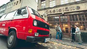 Red van parked outside an old tavern.