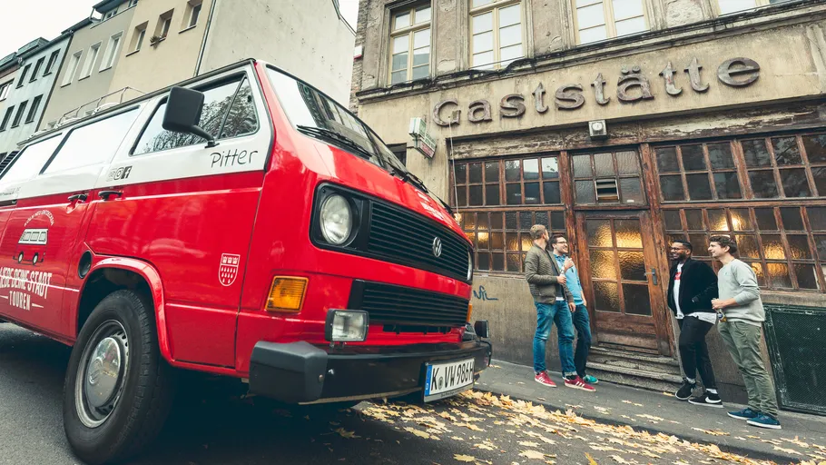 Red van parked outside an old tavern.