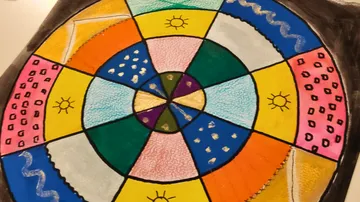 Buntes Muster mit geometrischen Formen und Symbolen.