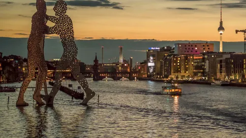 Skulptur im Fluss bei Sonnenuntergang, Stadtlandschaft.