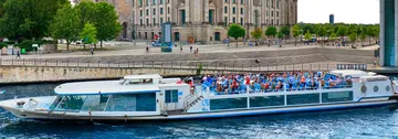 Tourboot kreuzt nahe Stadtgebäuden.