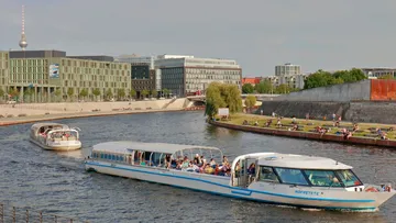 Boote fahren auf einem Stadtfluss, urbane Kulisse.