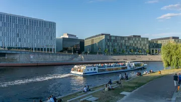 Boat cruising on river in urban area.