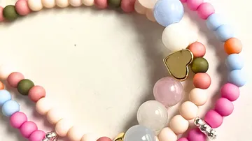 Colorful beaded bracelets with heart charm.