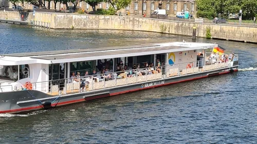 Touristen auf einem Solarschiff im Fluss.