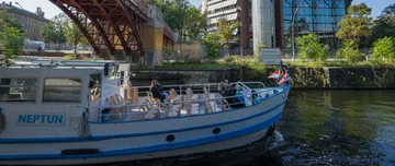 Boot fährt auf einem Fluss nahe Gebäuden.