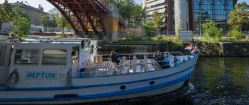 Boot auf Fluss nahe Gebäuden und Brücke.
