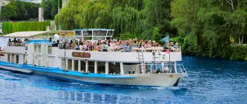 Boat with passengers cruising on a river.