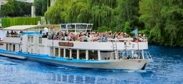 Touristenboot mit Passagieren auf einem Fluss.