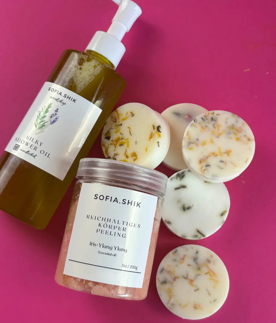 Shower oil, body scrub, discs on pink background.